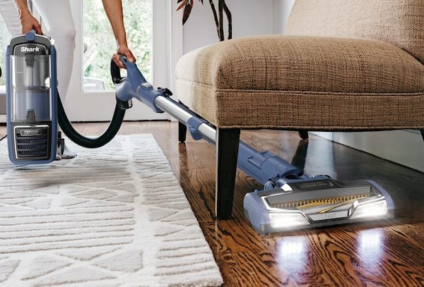 cleaning professional vacuuming under a chair