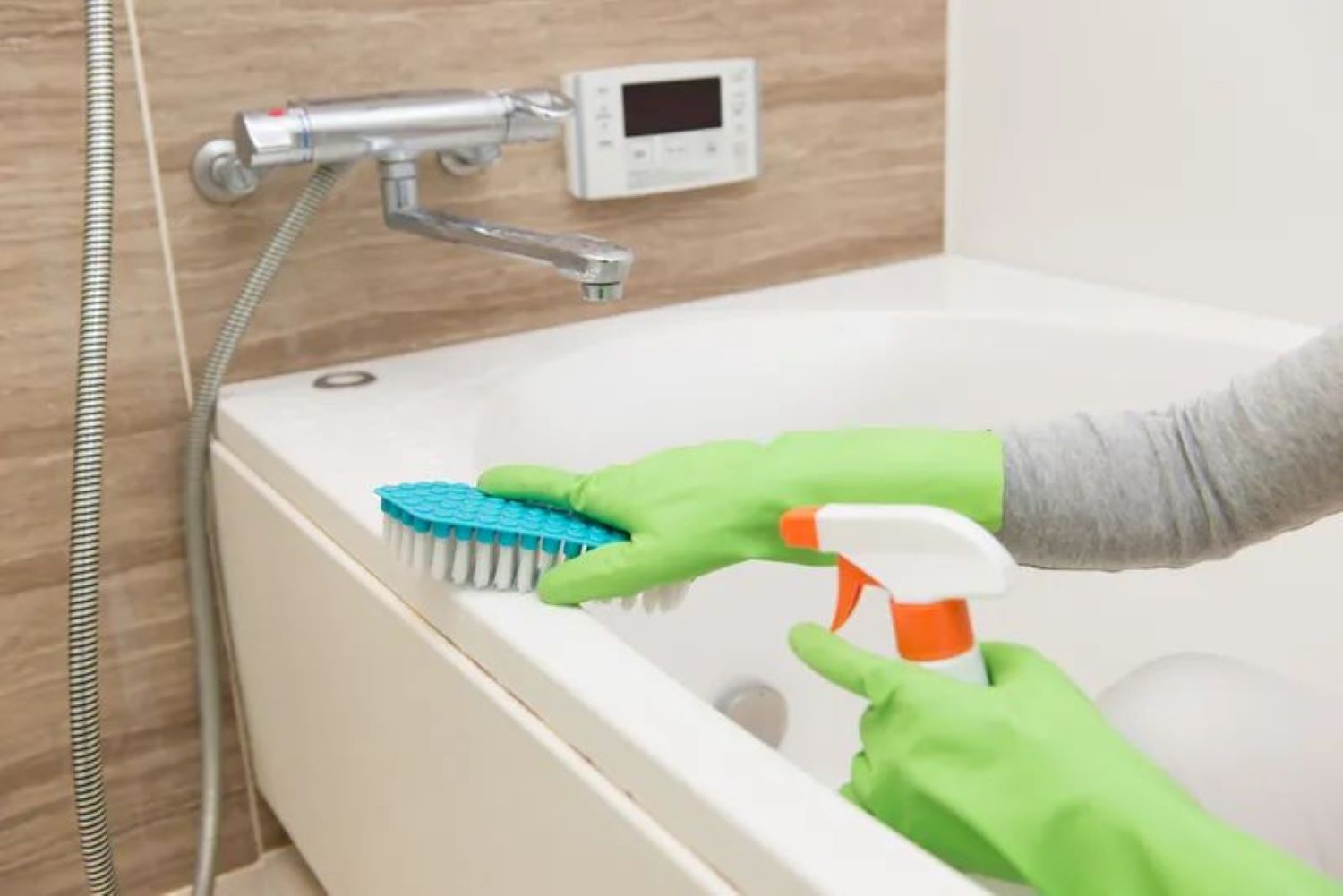 A professional cleaner cleaning a bathtub